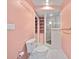 Cozy pink bathroom featuring a glass door shower and built in shelving for storage at 8011 N Mobley Rd, Odessa, FL 33556