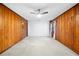 Bedroom with paneled walls, carpeted flooring, white accent wall, and ceiling fan at 8011 N Mobley Rd, Odessa, FL 33556
