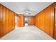 Bedroom with paneled walls, carpeted flooring, and ceiling fan at 8011 N Mobley Rd, Odessa, FL 33556
