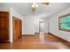 Spacious bedroom with hardwood floors, ceiling fan, closet, and natural light from the window at 8011 N Mobley Rd, Odessa, FL 33556