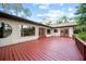 Large wooden deck perfect for gatherings, surrounded by windows and doors that offer scenic views of the garden at 8011 N Mobley Rd, Odessa, FL 33556