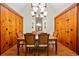 Elegant dining room featuring wood-paneled walls, hardwood floors, and a large chandelier at 8011 N Mobley Rd, Odessa, FL 33556