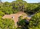 Sprawling single-story home with a chimney and a large, well-maintained roof, surrounded by lush greenery at 8011 N Mobley Rd, Odessa, FL 33556