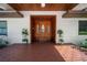 Inviting front entrance with a wood-stained porch and a decorative glass front door at 8011 N Mobley Rd, Odessa, FL 33556