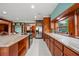 Bright kitchen features stainless appliances, granite counters, wood cabinets, and tile floors at 8011 N Mobley Rd, Odessa, FL 33556