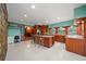 Eat-in kitchen features a center island with bar seating, tile floors, and wood cabinets at 8011 N Mobley Rd, Odessa, FL 33556