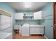 Laundry room with washer, dryer, sink, and storage cabinets at 8011 N Mobley Rd, Odessa, FL 33556