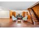 Open-concept living room with hardwood floors, wood paneling, and staircase to second floor at 8011 N Mobley Rd, Odessa, FL 33556