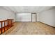 Large living room with carpeted flooring, wooden railing, and white walls at 8011 N Mobley Rd, Odessa, FL 33556