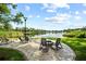 Scenic outdoor patio with seating and a fire pit overlooking a tranquil lake at 8011 N Mobley Rd, Odessa, FL 33556