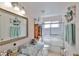 A spacious bathroom featuring a granite vanity top, framed mirror and a glass shower enclosure at 8916 Southbay Dr, Tampa, FL 33615