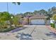 Well-maintained home with a two-car garage, mature trees and landscaping, and a brick-paved driveway at 8916 Southbay Dr, Tampa, FL 33615