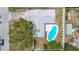 Aerial view of the house showcasing the backyard with a large pool, patio area, and lush landscaping at 10006 N Connechusett Rd, Tampa, FL 33617
