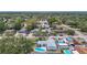 Aerial view shows in ground blue pool with patio in a neighborhood with mature trees and other homes at 10006 N Connechusett Rd, Tampa, FL 33617
