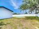 Backyard featuring an in-ground pool, mature trees, and a white privacy fence on a sunny day at 10006 N Connechusett Rd, Tampa, FL 33617