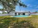 Landscaped backyard featuring private pool area with lush green grass and white house at 10006 N Connechusett Rd, Tampa, FL 33617