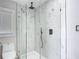 Modern bathroom featuring a glass shower with marble-look tile and a sleek, minimalist design at 10006 N Connechusett Rd, Tampa, FL 33617