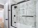 Bathroom with a marble tiled shower and black trim, providing a modern aesthetic at 10006 N Connechusett Rd, Tampa, FL 33617