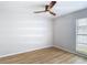 Bedroom with wood-look flooring, ceiling fan and natural light from window at 10006 N Connechusett Rd, Tampa, FL 33617