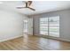 Bright bedroom with wood flooring, a ceiling fan, and a large window overlooking a sparkling pool at 10006 N Connechusett Rd, Tampa, FL 33617