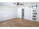 Spacious bedroom with wood-look floors, a modern ceiling fan, and a sliding barn door at 10006 N Connechusett Rd, Tampa, FL 33617