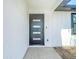 Modern front door with glass inserts, a digital lock, and a freshly painted exterior at 10006 N Connechusett Rd, Tampa, FL 33617