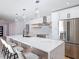 Open kitchen with a large island, pendant lighting, stainless steel appliances, and wood accents at 10006 N Connechusett Rd, Tampa, FL 33617