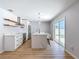 Bright and modern kitchen featuring white cabinets, stainless steel appliances, island seating and a view to the backyard at 10006 N Connechusett Rd, Tampa, FL 33617