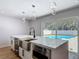 Bright kitchen island with stainless steel sink and appliances, and a view of the pool at 10006 N Connechusett Rd, Tampa, FL 33617