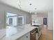 Modern kitchen island with white countertops, stainless steel sink, and stylish pendant lighting at 10006 N Connechusett Rd, Tampa, FL 33617