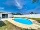 Inviting backyard with a private in-ground pool and a surrounding concrete patio and fresh lawn at 10006 N Connechusett Rd, Tampa, FL 33617
