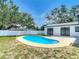 Private in-ground pool with mature trees and white fence in a green backyard at 10006 N Connechusett Rd, Tampa, FL 33617