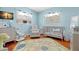 Serene Bedroom with wooden floors, leaf rug, gray furniture, crib, and playful dinosaur accents at 1003 W Indiana Ave, Tampa, FL 33603