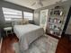 Serene bedroom featuring hardwood floors, large windows, and a decorative bookshelf at 1003 W Indiana Ave, Tampa, FL 33603