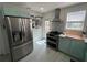 Modern kitchen featuring stainless steel appliances, aqua lower cabinets, and a stainless steel range hood at 1003 W Indiana Ave, Tampa, FL 33603