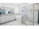 Modern bathroom featuring marble tile, glass shower, soaking tub, and double vanity with stylish lighting at 10111 Tuscan Sun Ave, Riverview, FL 33578