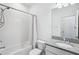 All-white bathroom features a shower-tub combination and granite vanity at 10111 Tuscan Sun Ave, Riverview, FL 33578