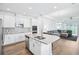 Open concept with white kitchen cabinets, stainless appliances, and large center island at 10111 Tuscan Sun Ave, Riverview, FL 33578