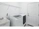 Well-lit laundry room features modern washer and dryer, utility sink, wire shelving, and door to exterior at 10111 Tuscan Sun Ave, Riverview, FL 33578