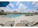 Community pool with lounge chairs, umbrellas, and a spacious deck for relaxation and socializing at 10111 Tuscan Sun Ave, Riverview, FL 33578