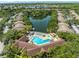Aerial view showcasing the complex with a large lake, and a pool with sun loungers at 10511 Waterview Ct # 10511, Tampa, FL 33615