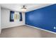 Carpeted bedroom featuring a blue accent wall, ceiling fan, and window with dark curtains at 10511 Waterview Ct # 10511, Tampa, FL 33615