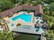 Aerial view featuring a pool, and a lake, complete with lounge chairs and tiki huts at 10511 Waterview Ct # 10511, Tampa, FL 33615