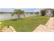 Manicured backyard featuring a lush lawn, lake view, and white picket fence at 11684 Brighton Knoll Loop, Riverview, FL 33579