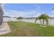 Well-manicured backyard featuring lush lawn, white picket fence, and partial lake view at 11684 Brighton Knoll Loop, Riverview, FL 33579