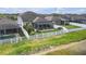 Beautifully landscaped backyard with a white fence, screened-in lanai, and lush green grass at 11684 Brighton Knoll Loop, Riverview, FL 33579