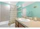 Well-lit bathroom with vanity, a tub with shower, and nautical decor at 11684 Brighton Knoll Loop, Riverview, FL 33579