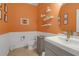 Bright bathroom with orange walls, white wainscoting, and modern vanity at 11684 Brighton Knoll Loop, Riverview, FL 33579