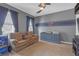 Cozy bedroom with dark trim, a ceiling fan, and a large sofa at 11684 Brighton Knoll Loop, Riverview, FL 33579