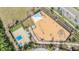 Aerial view of the community playground featuring a basketball court, swings, and play equipment under a sunshade at 11684 Brighton Knoll Loop, Riverview, FL 33579